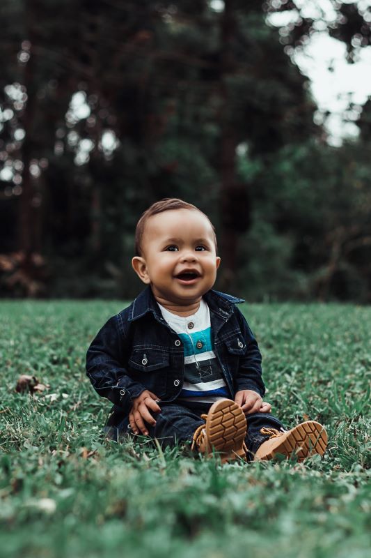 a baby sitting in the grass