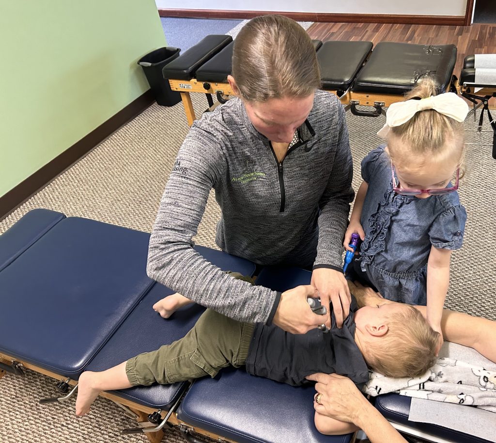 Chiropractor adjusting toddler’s spine to relieve ear infection symptoms