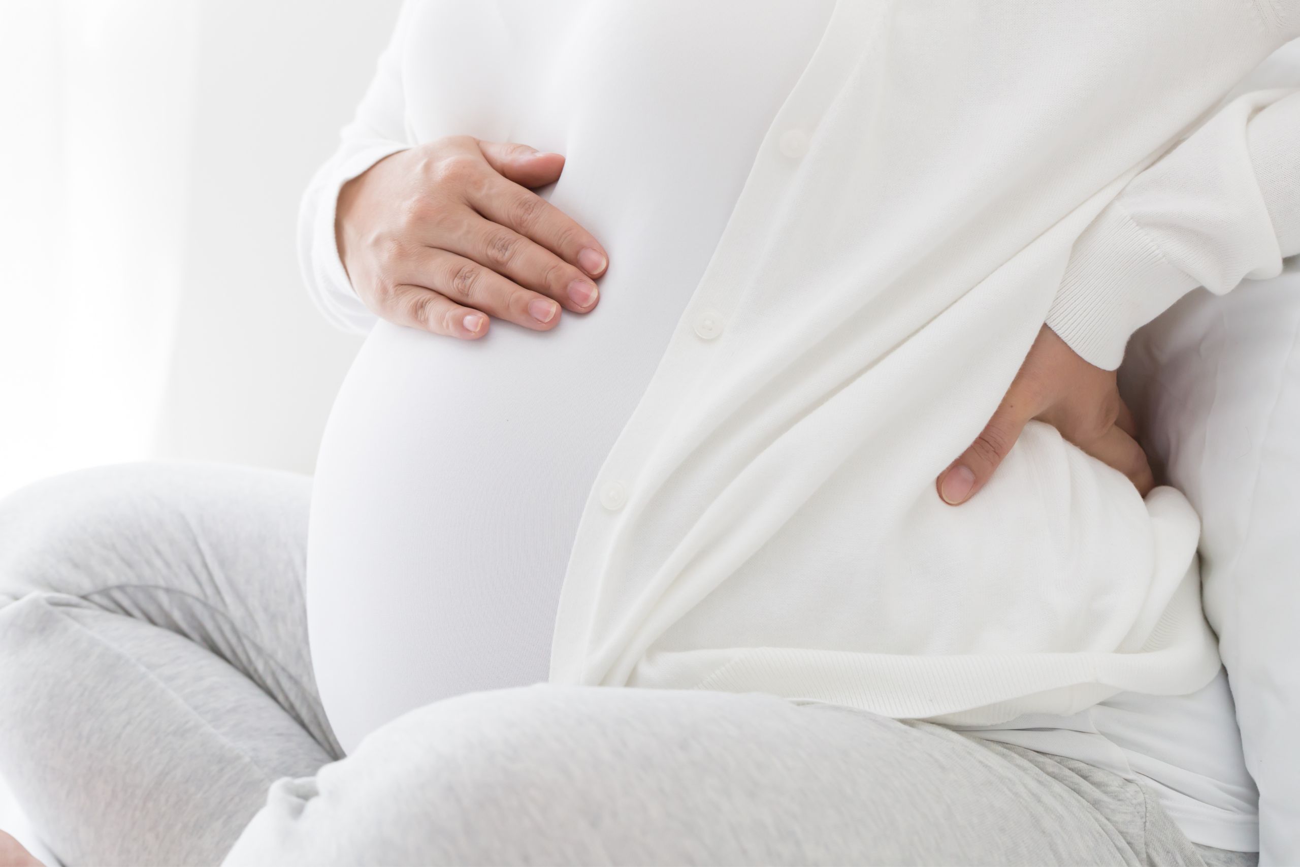 prenatal chiropractic care helping pregnant woman in white clothing